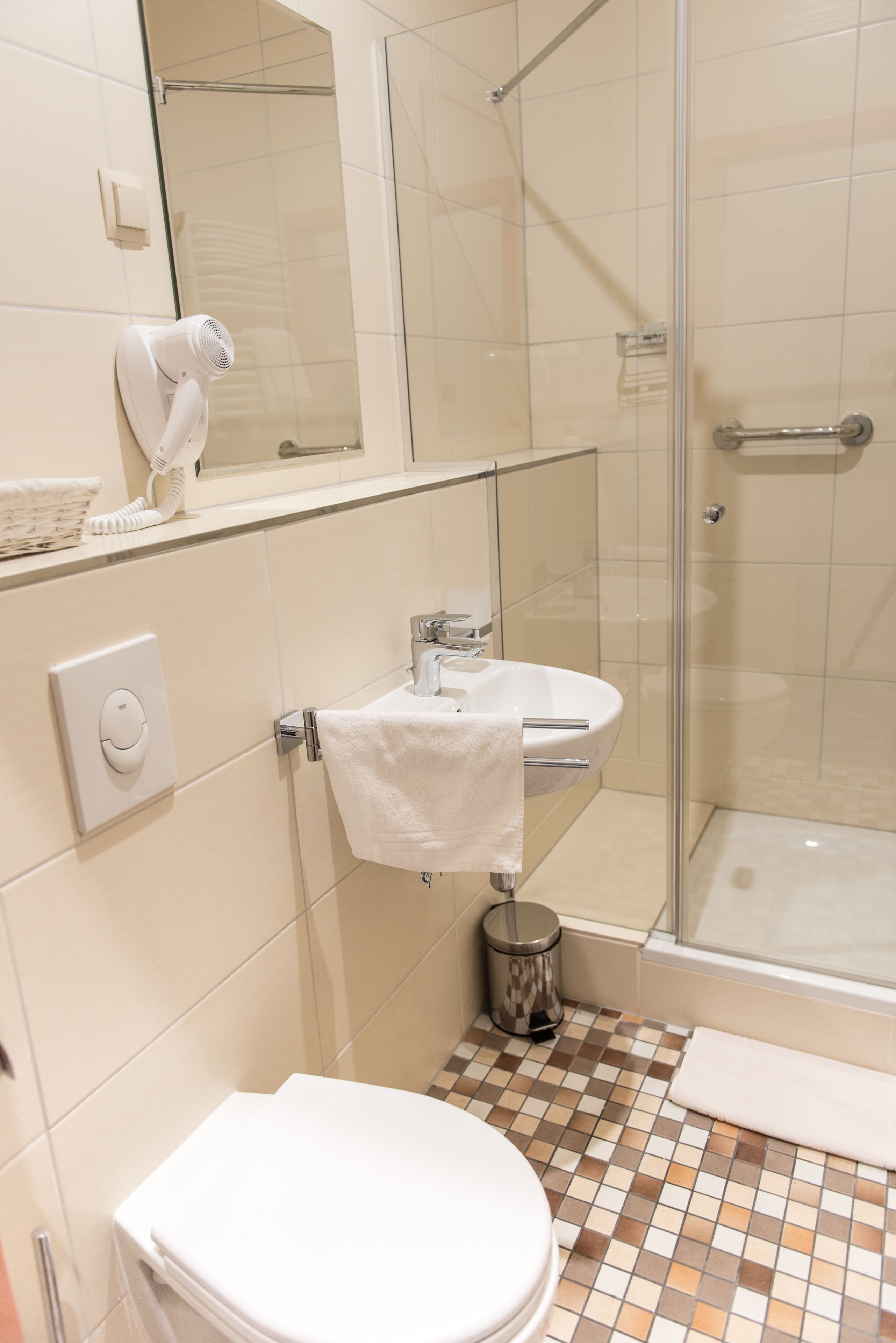 Un baño con inodoro, lavamanos y zona de ducha.