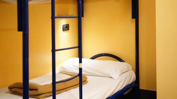 Una cama litera con escalera, ropa de cama blanca y una manta marrón.