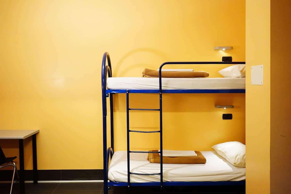 Une chambre avec un lit superposé, un bureau et une chaise.