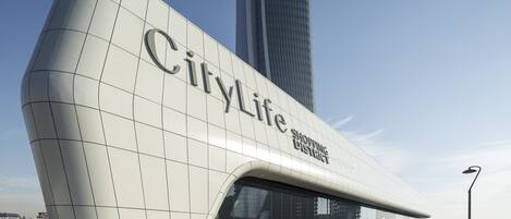 Un edificio moderno con el nombre "CityLife Shopping District" bien visible en su fachada.