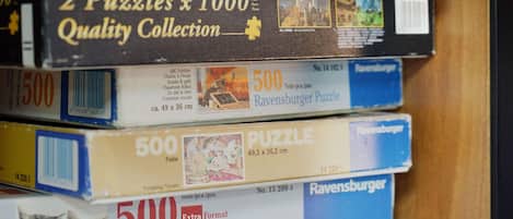 Una pila de rompecabezas Ravensburger de distintos tamaños y temas.