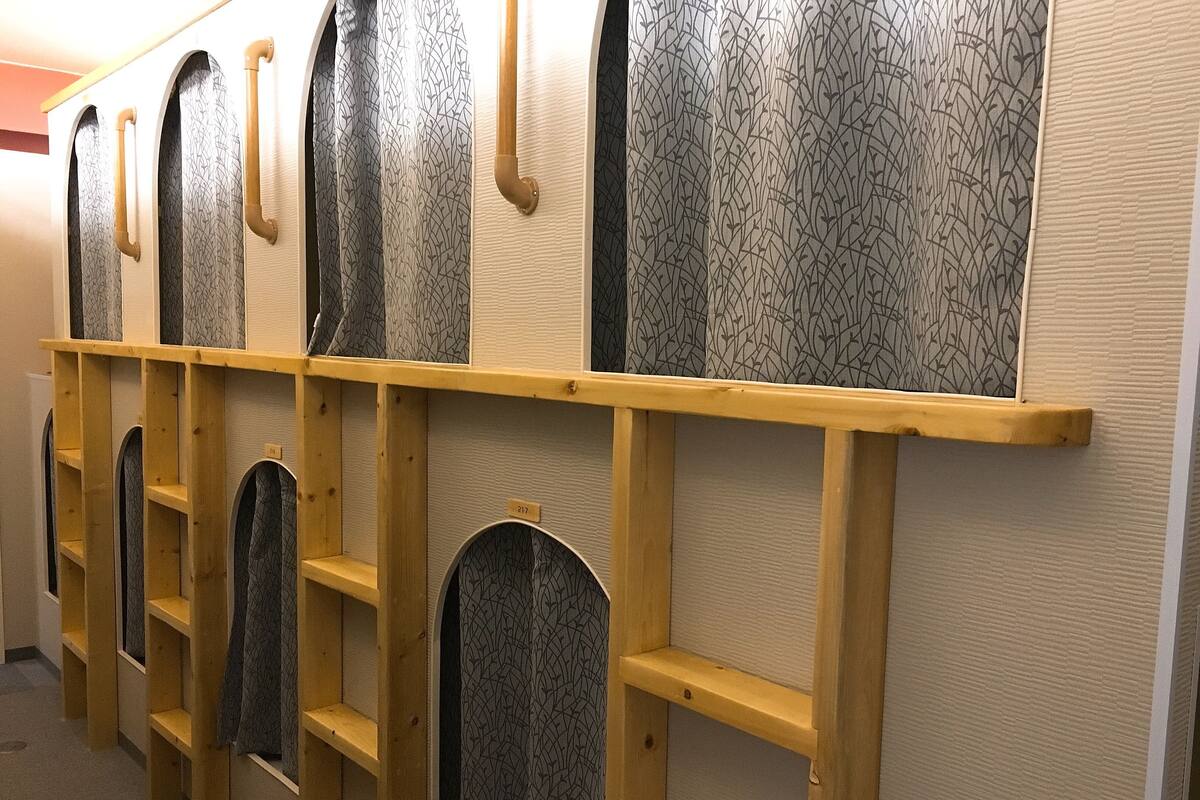 A row of wooden shelves with patterned curtains and a number tag.