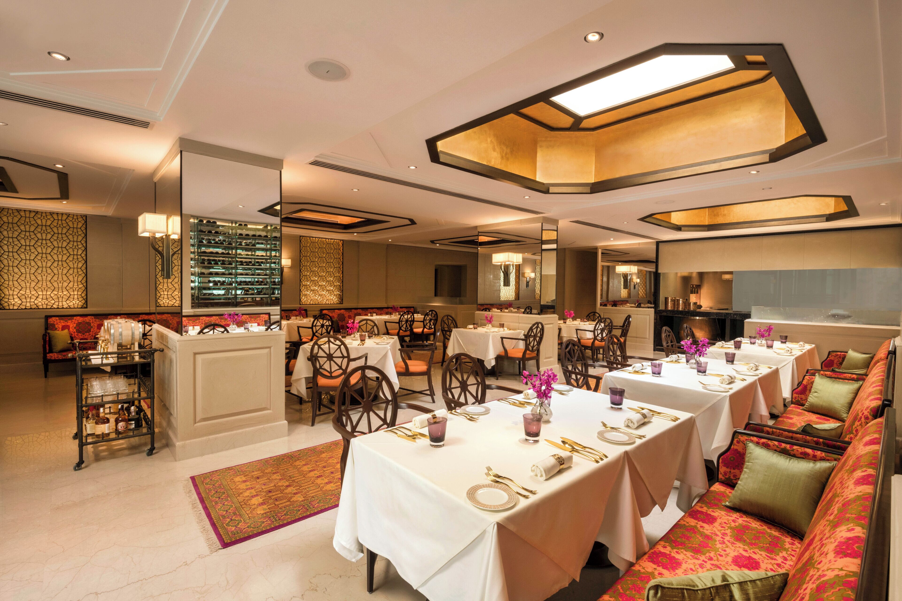 A spacious dining area with multiple tables and chairs, a bar area, and a seating section with sofas.