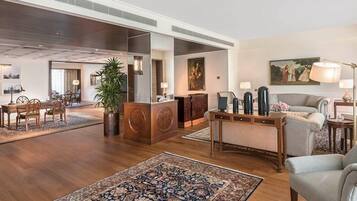 Um amplo hall com balcão de recepção, área de estar e uma grande planta.