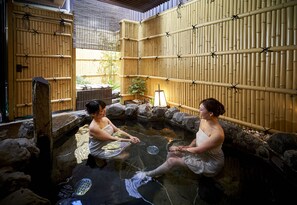 A traditional Japanese onsen with stone walls and bamboo screens. - Hotel Kuu Kyoto (Kyoto)