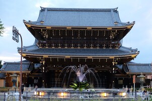 A traditional Japanese building with a multi-tiered roof and a central fountain.