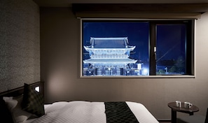 A hotel room with a large window overlooking a traditional building at night. - Hotel Kuu Kyoto (Kyoto)