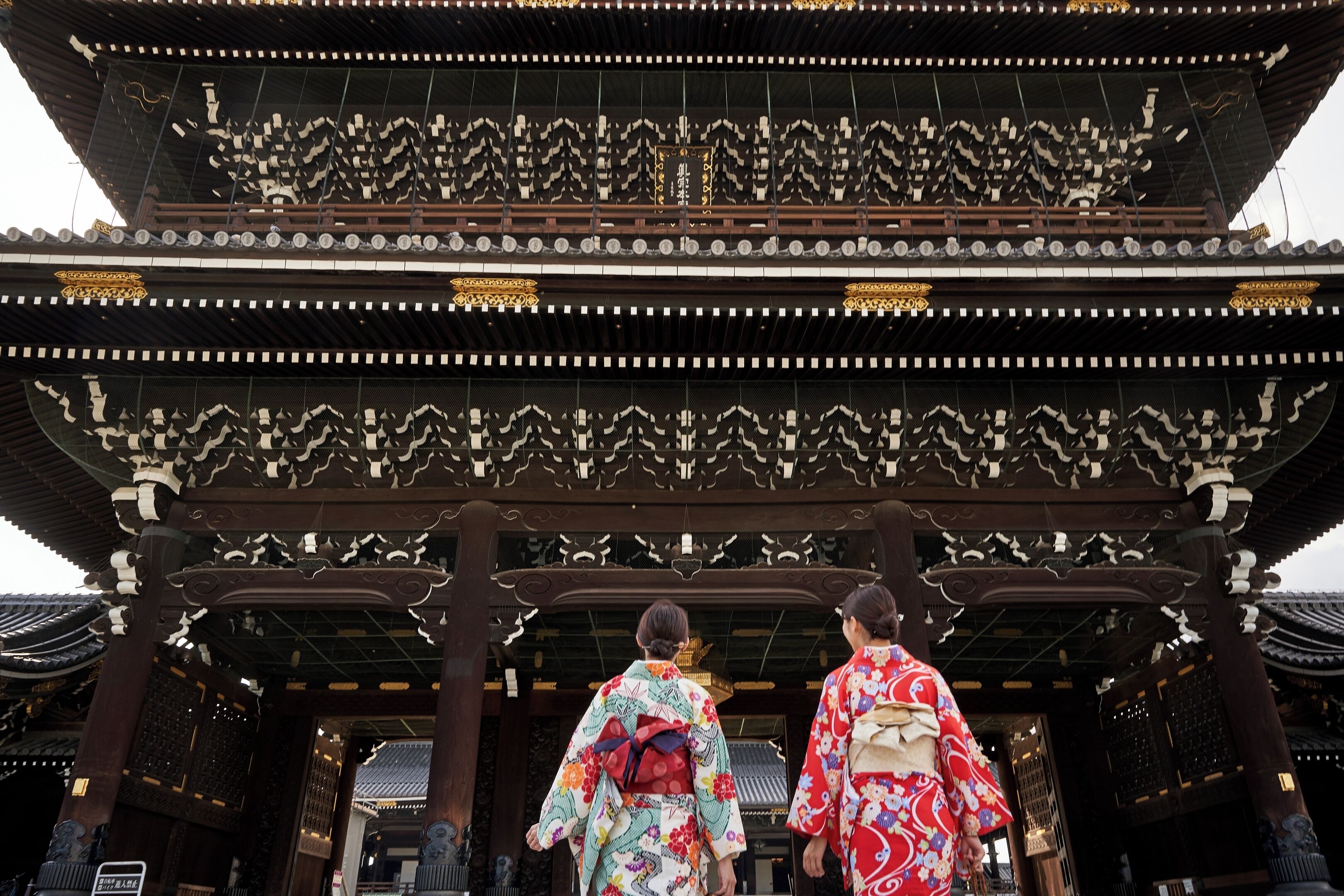 A traditional Japanese building with a multi-tiered roof and ornate wooden beams.