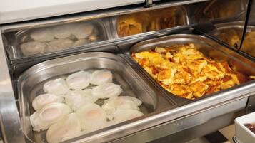 A buffet with various food items including poached eggs and scrambled eggs.