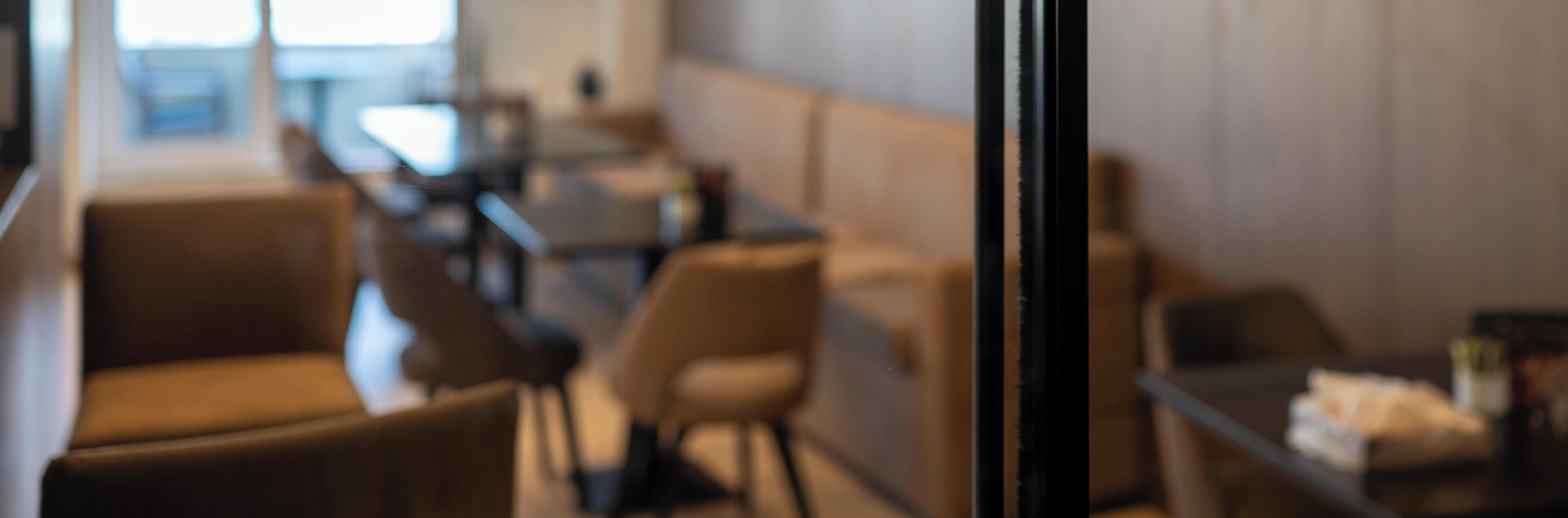 Une vue floue de l’intérieur d’une salle à manger, avec des tables et des chaises.