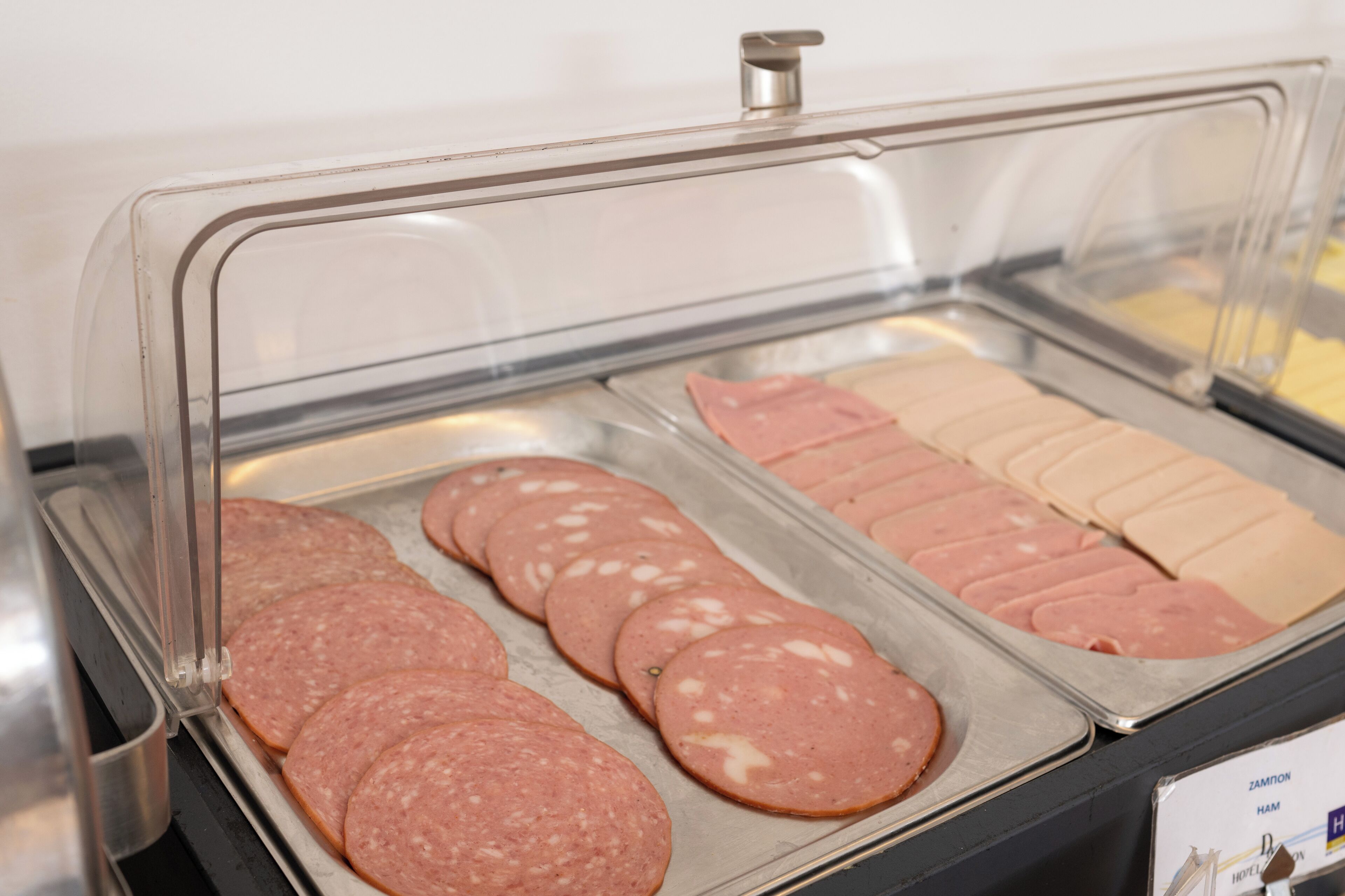 A deli counter with sliced meats displayed in a clear case.