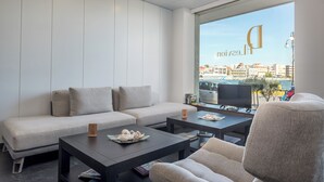 Una sala de estar moderna con un sofá, dos mesas auxiliares y un televisor.