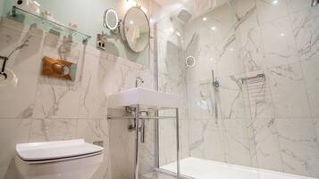Deluxe Suite | Bathroom | Shower, designer toiletries, slippers, towels