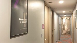 A hallway with a sign that reads "STAY SAFE & SOUND" and a number "2" on the wall. - Studio Ekamai (Bangkok)