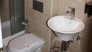 A bathroom with a toilet, sink, and shower. - ETN Hotel (Sarajevo)