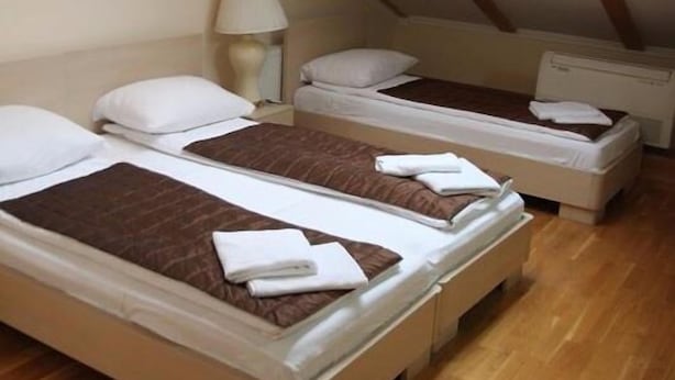 A dormitory room with three single beds, wooden flooring, and skylights. - ETN Hotel (Sarajevo)