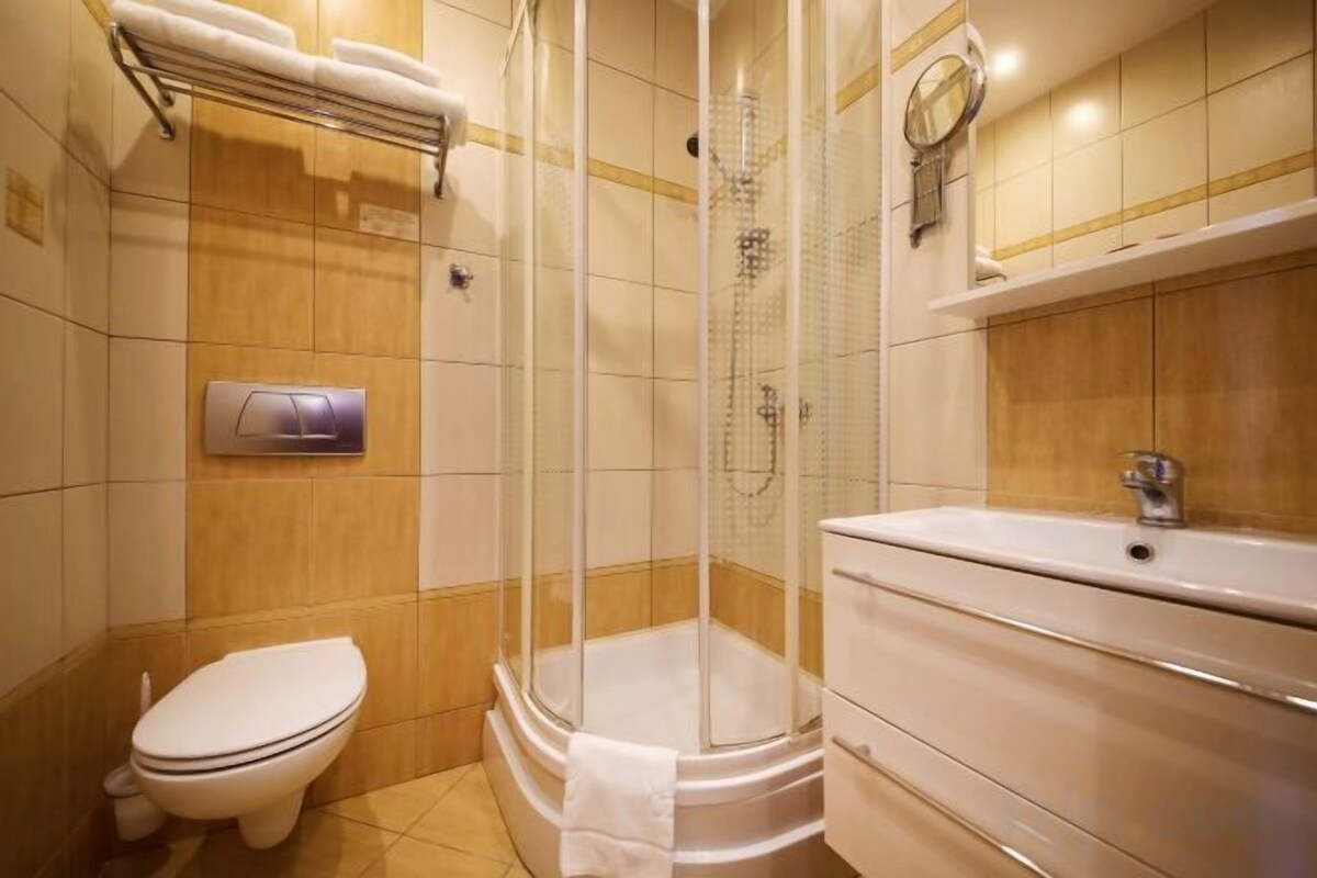 A bathroom with a shower, toilet, and sink.