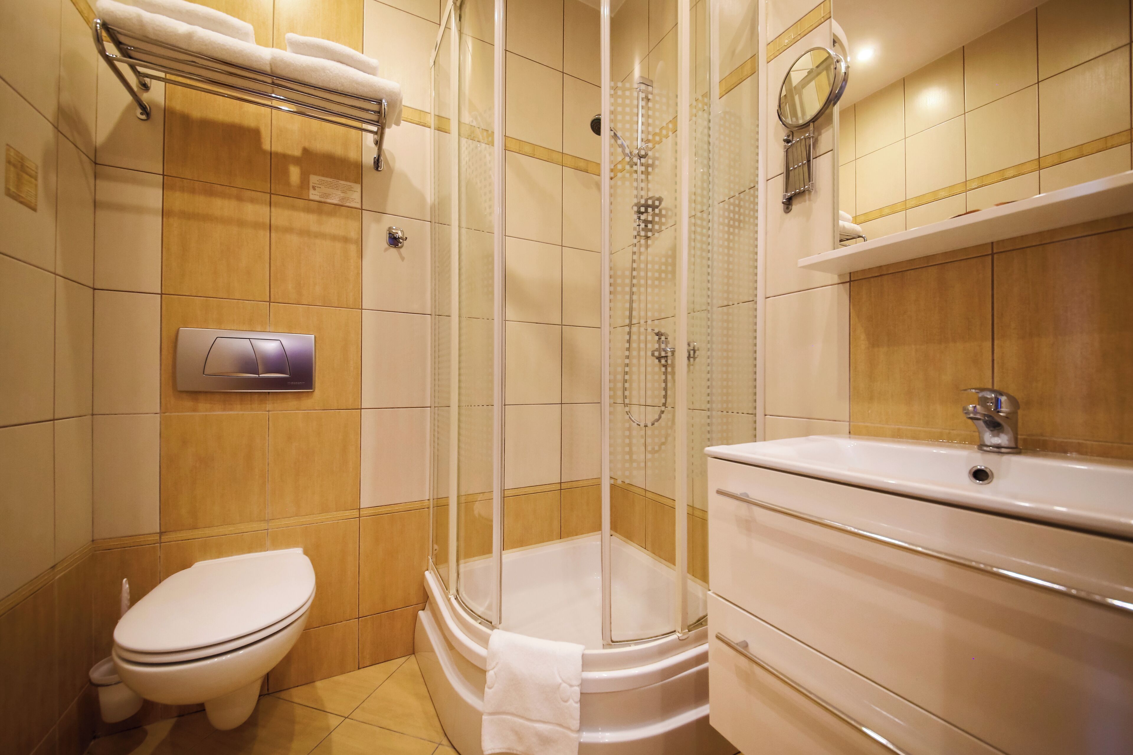 A bathroom with a toilet, a glass-enclosed shower, and a sink.