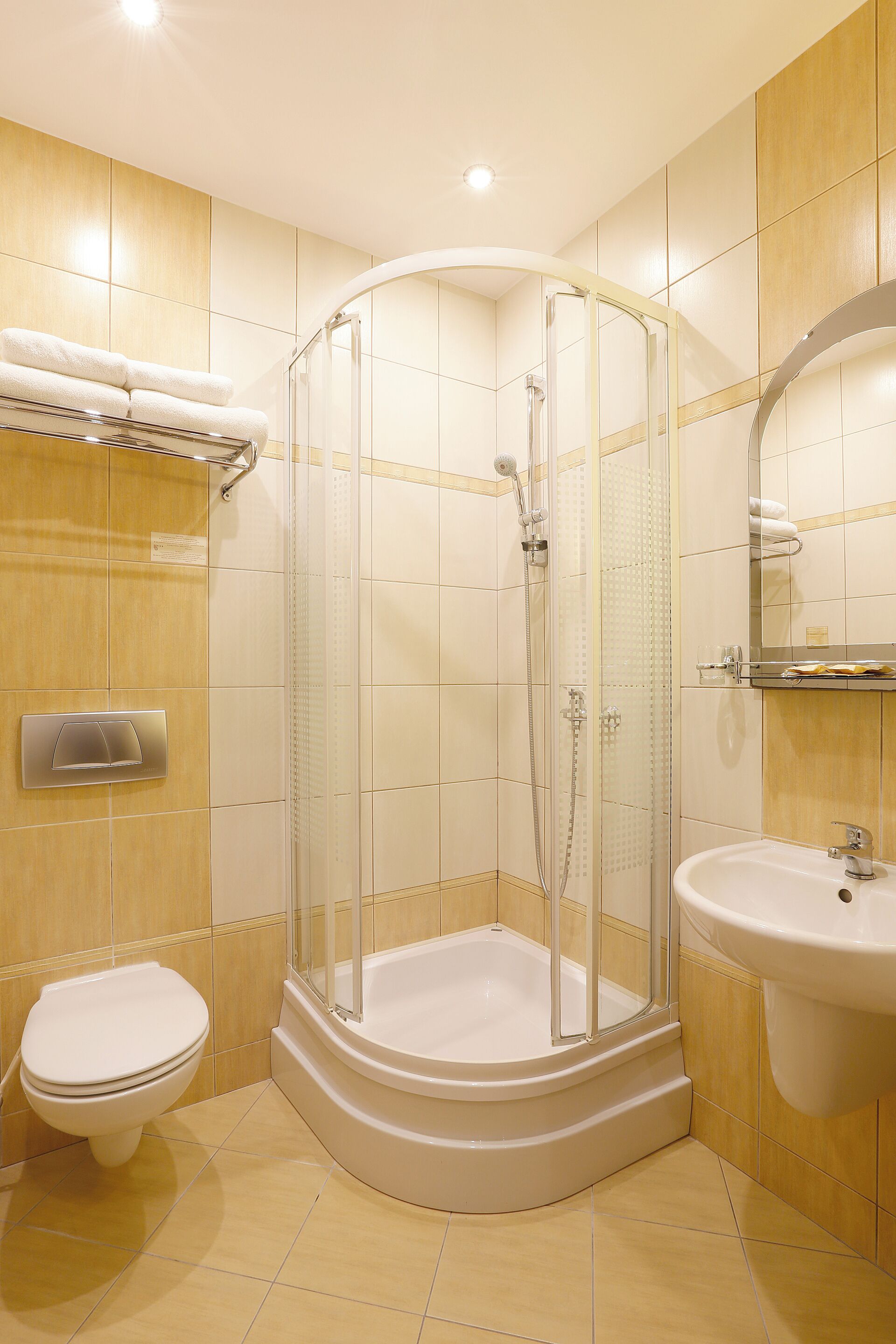 Un baño moderno con ducha acristalada, inodoro y lavabo.