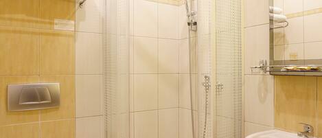 Un baño moderno con ducha acristalada, inodoro y lavabo.