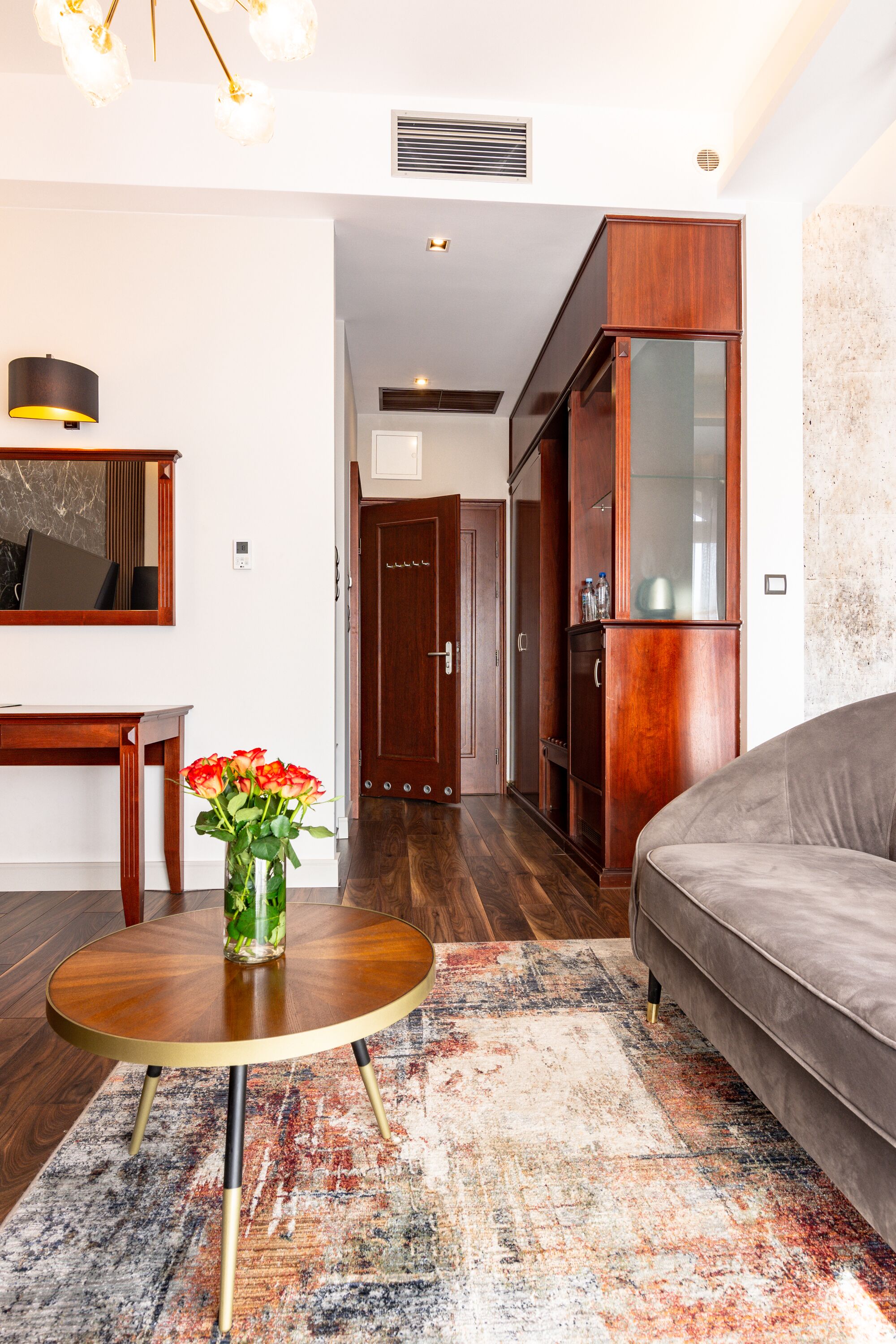 A modern living room with a round coffee table, a sofa, and a wooden cabinet.