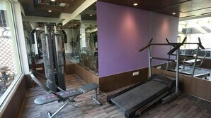A gym with a treadmill, weight machines, and a bench.