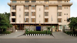 A multi-story hotel with a flat facade, large windows, and a sign indicating it is the Limon Tree Hotel.