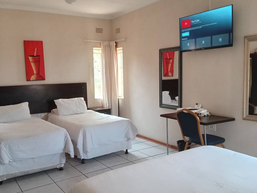 Eenvoudige vierpersoonskamer, uitzicht op tuin | Een bureau, een laptopwerkplek, een strijkplank/strijkijzer, gratis wifi