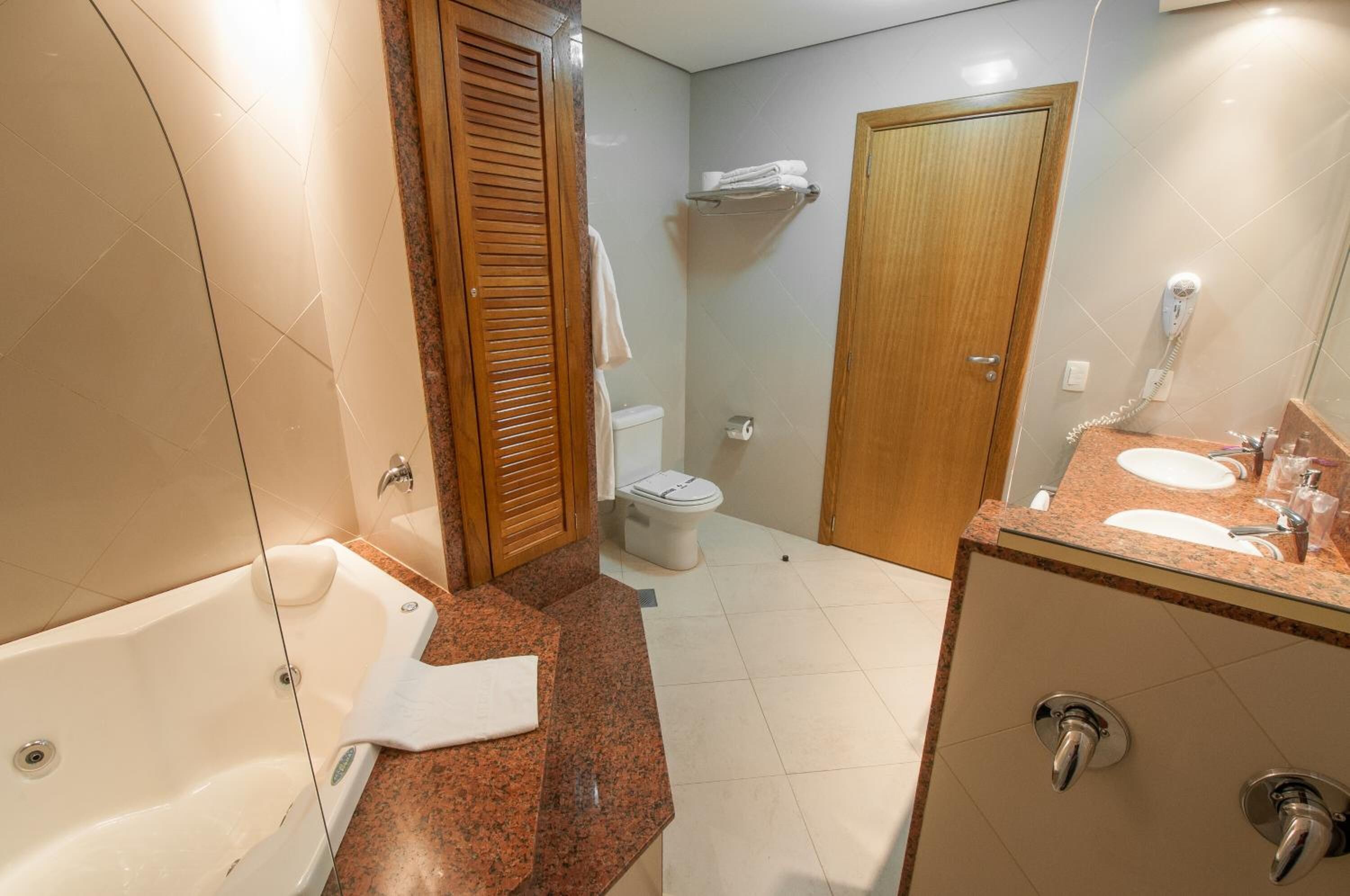 A bathroom with a bathtub, a toilet, a sink, and a shower area.