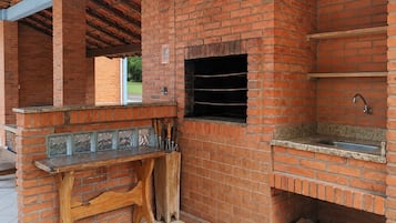 An outdoor brick barbecue area with a sink and a window.
