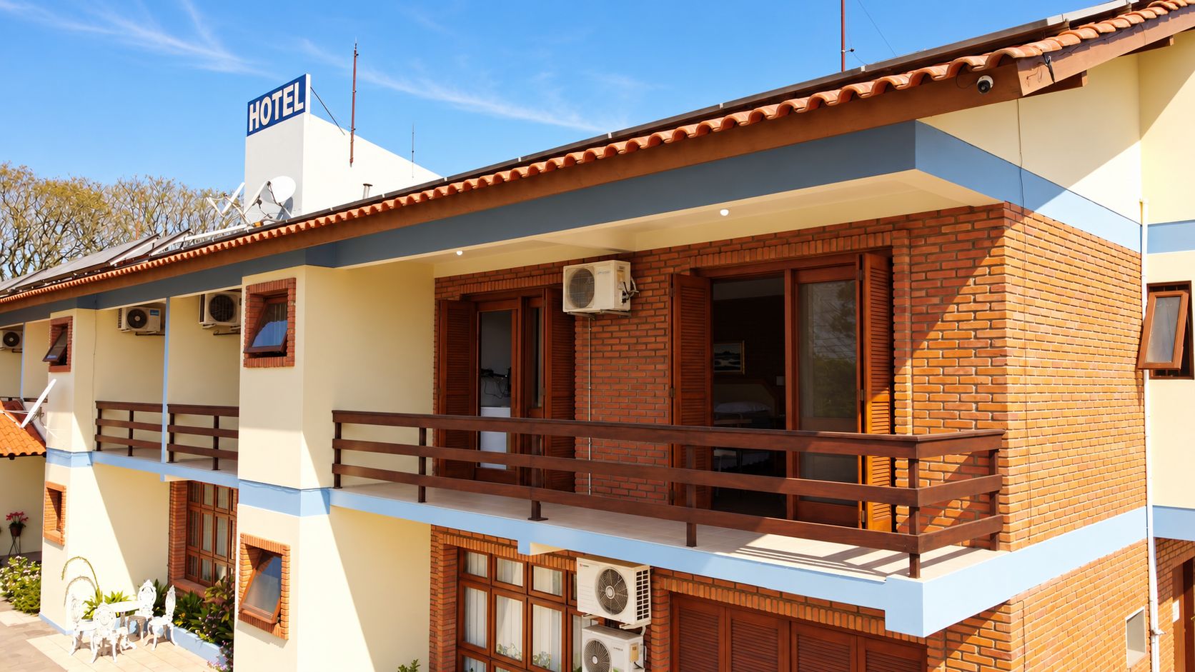 Un hotel con balcón, unidades de aire acondicionado y un cartel que indica que se trata de un hotel.
