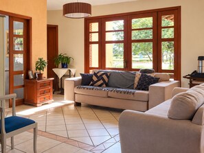 A living room with a sofa, a chair, a coffee table, and a potted plant. - Sítio Hotel e Eventos (Sao Pedro do Sul)