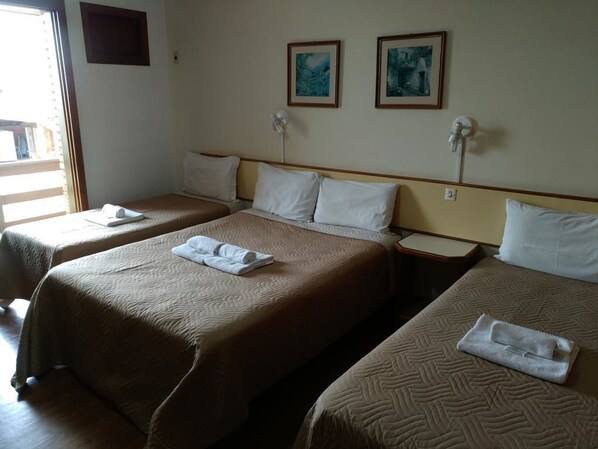 A hotel room with two beds, each with a brown quilt and white pillows. There are two framed pictures on the wall above the beds. - Sítio Hotel e Eventos (Sao Pedro do Sul)