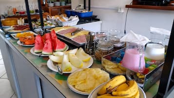 Un bufé con diversas frutas, verduras y bebidas.