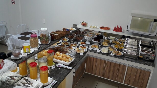 A buffet with various food items and beverages. - Hotel Guima (Santa Vitoria)