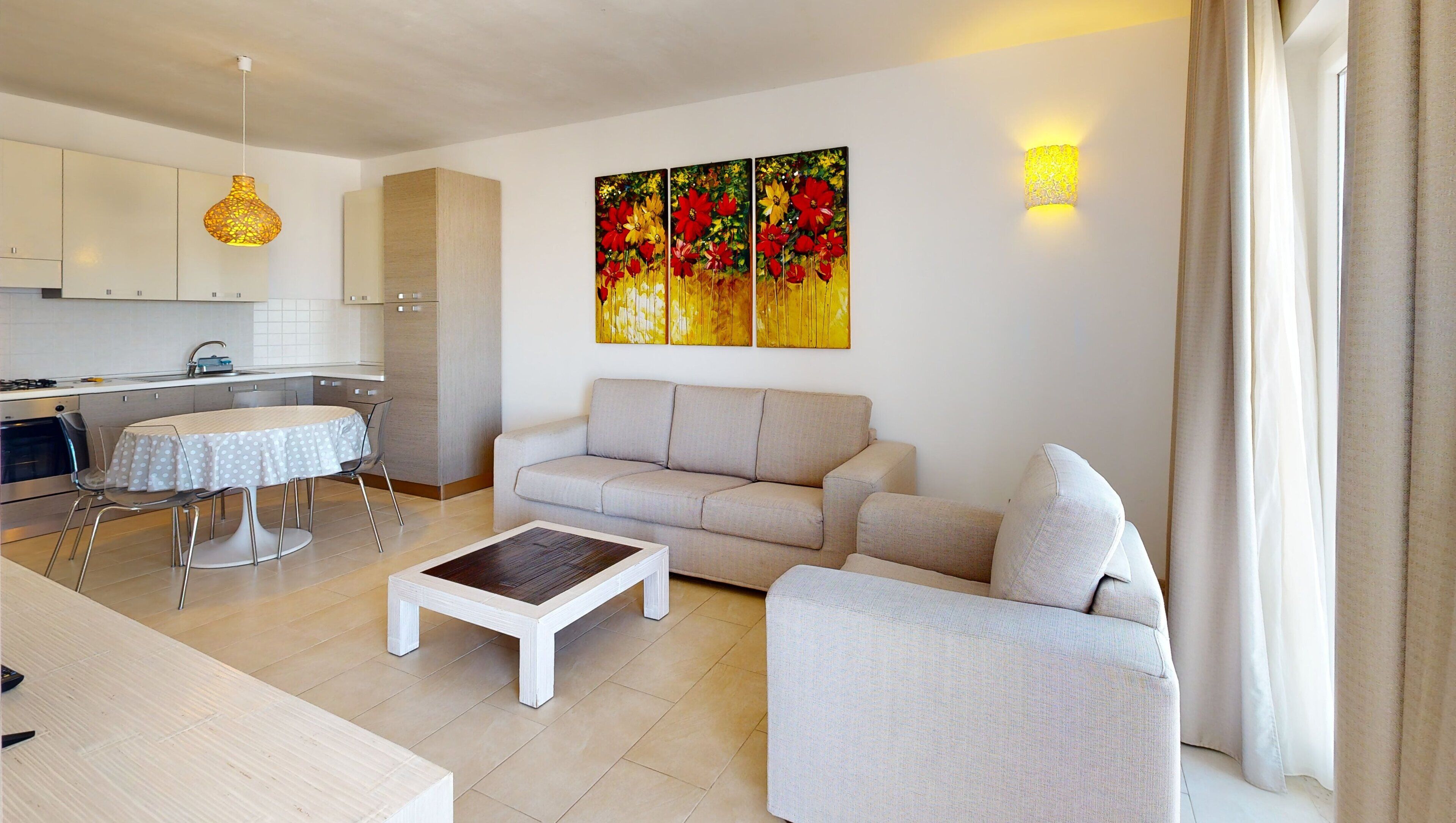 A modern living room with a sofa, a coffee table, and a dining area with a table and chairs.