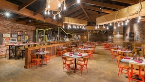 A restaurant with brick walls, wooden beams, and a long bar area. Tables and chairs are arranged for dining. - Tioga Downs Casino and Resort (Nichols)