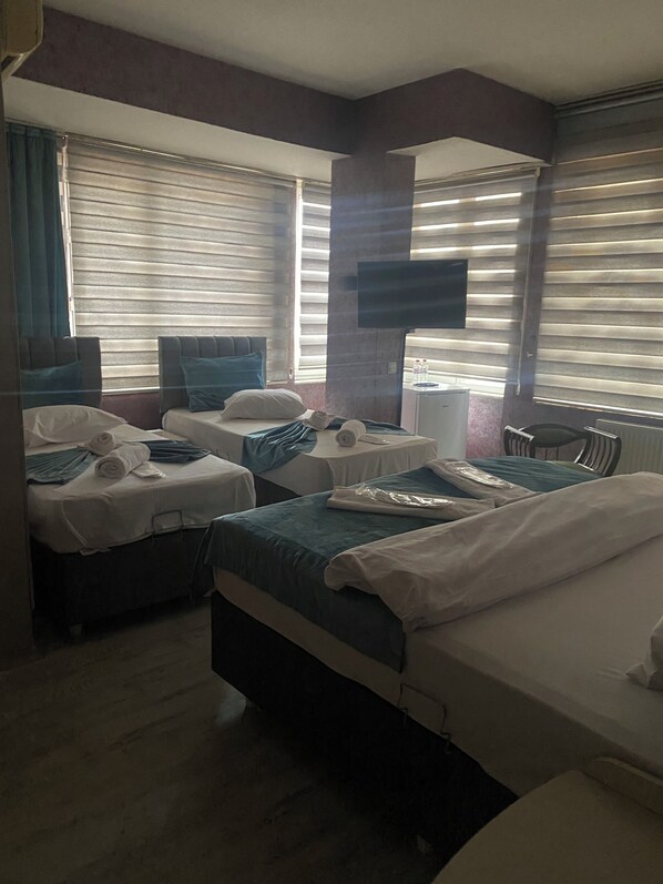 A hotel room with two beds, a flat-screen TV, a desk, and a chair.