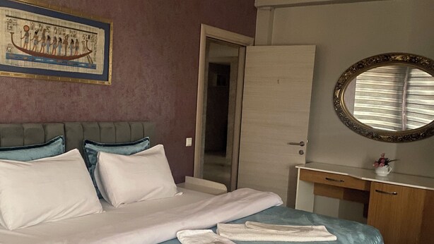 A hotel room with a bed, a desk, a mirror, and a door. - Masal Otel (Izmit)
