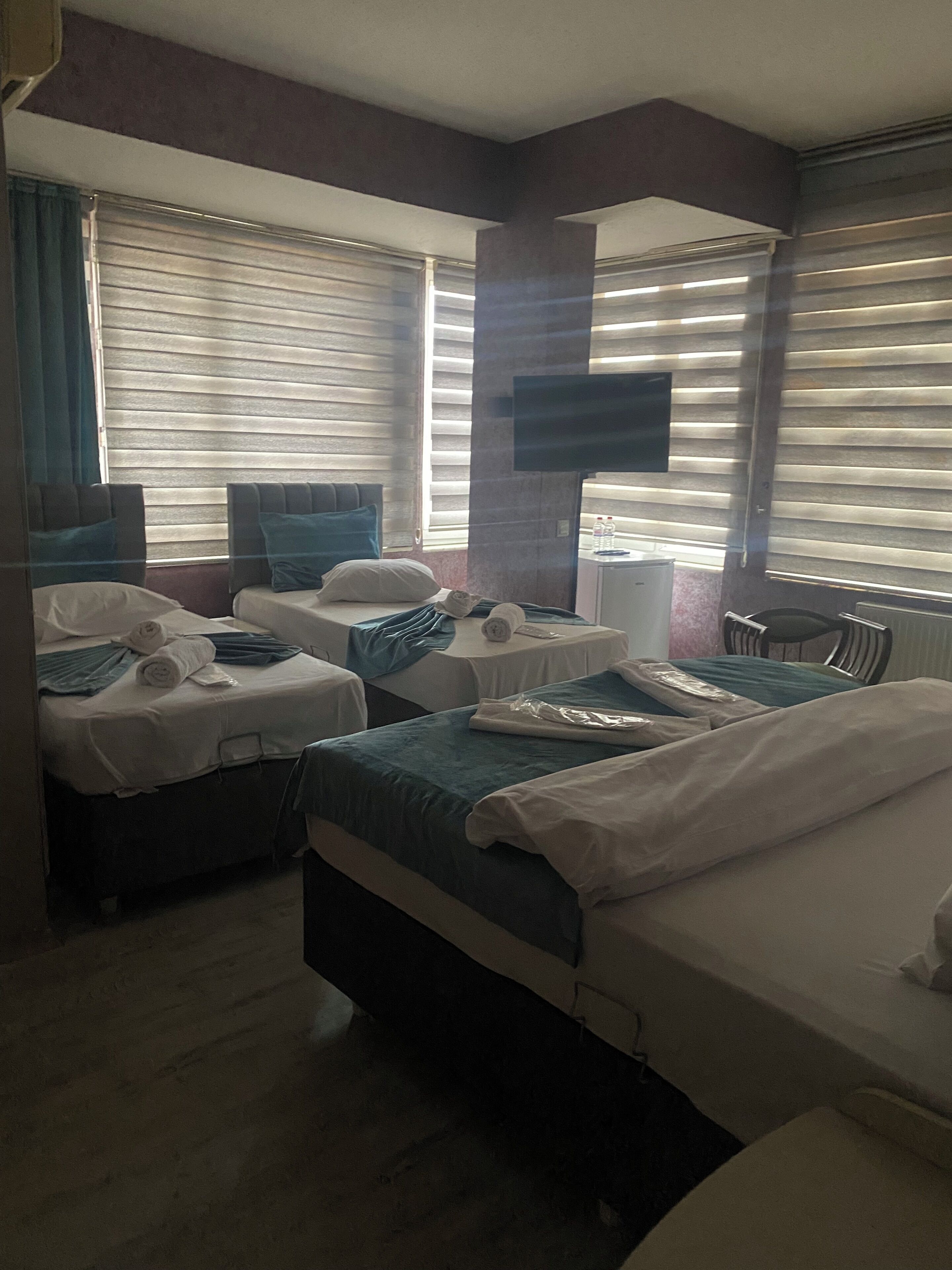 A hotel room with two beds, a flat-screen TV, a desk, and a chair.