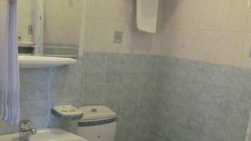 Casa de banho com lavatório, sanita e porta-toalhas.