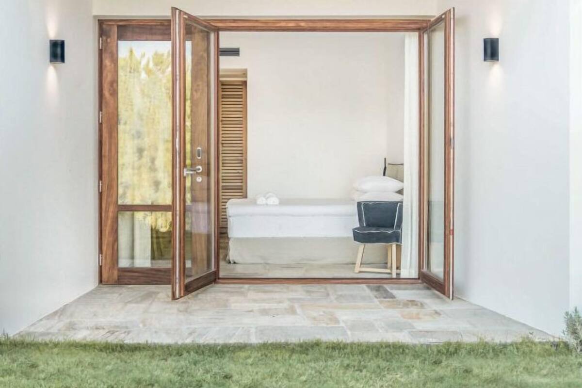A room with a bed, a chair, and a small table.