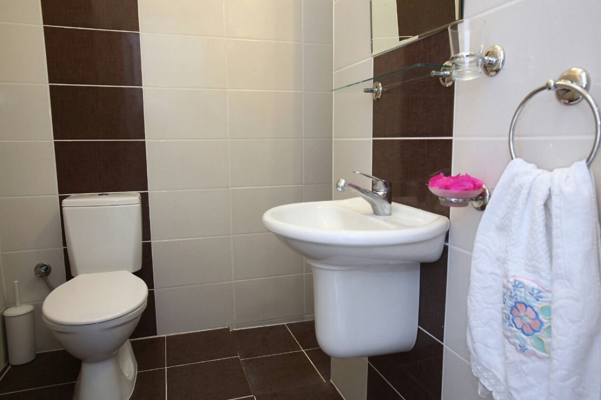 Un baño con inodoro, lavamanos y cabina de ducha de vidrio.