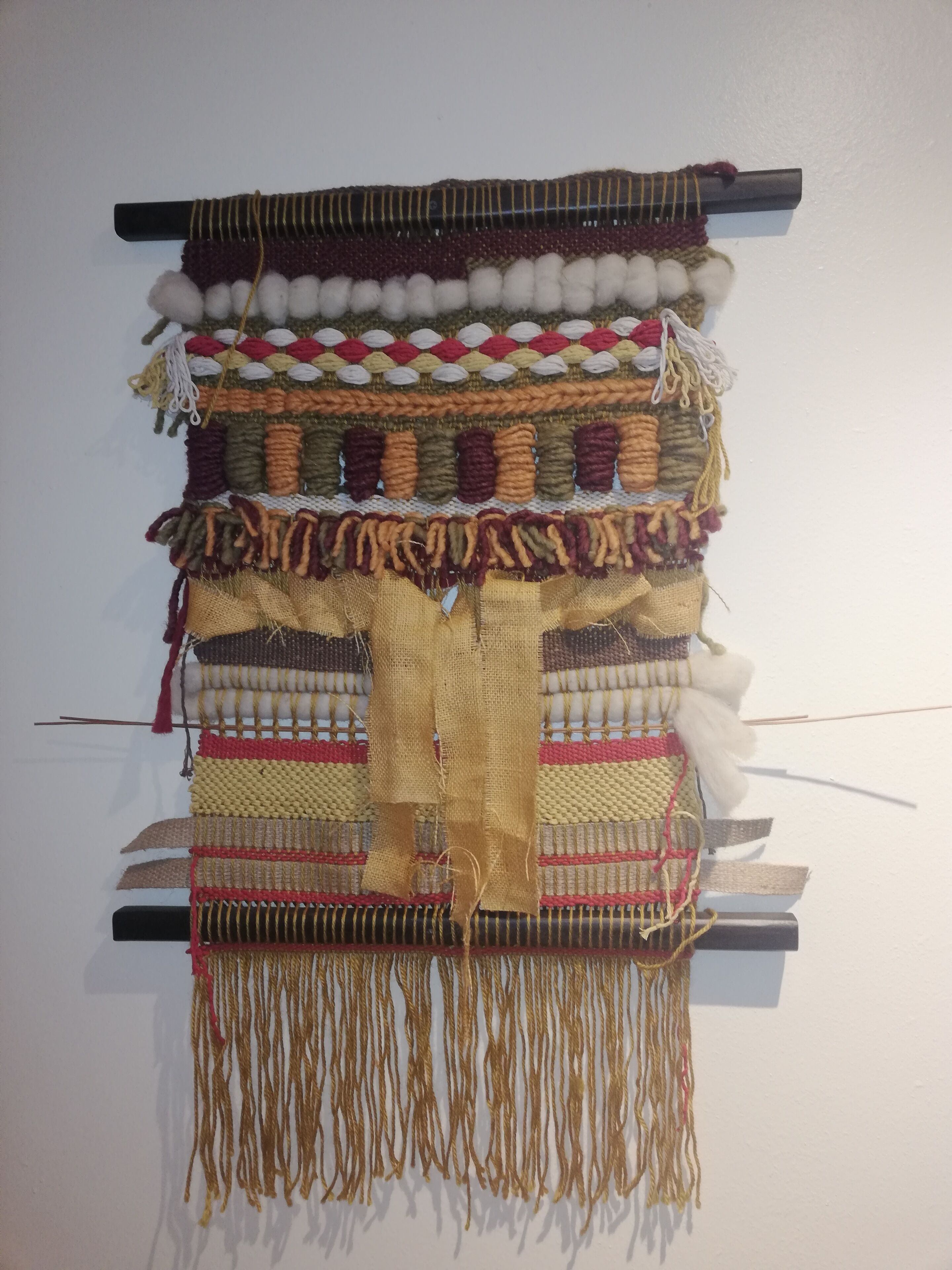 Een wandtapijt met verschillende texturen en patronen.