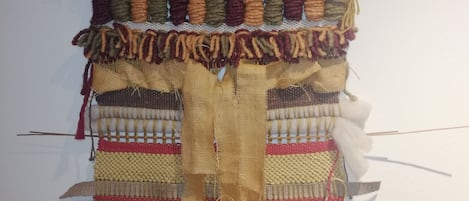 A wall-mounted tapestry with various textures and patterns.