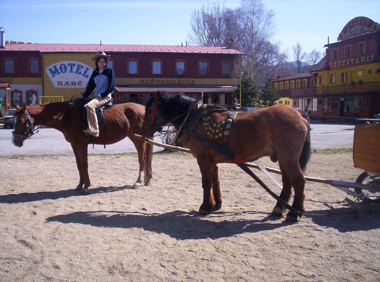 Une personne se promenant en calèche devant un motel appelé « Motel Ranch ».