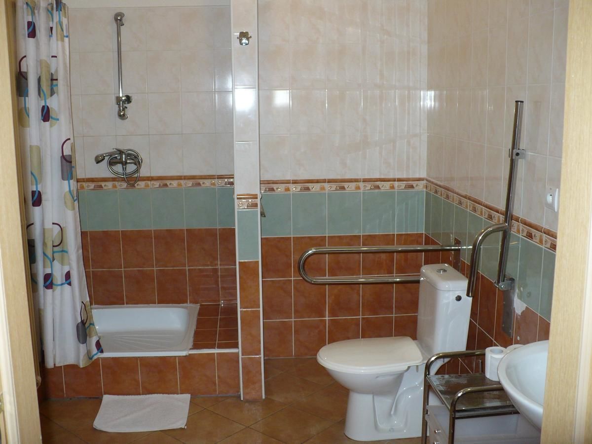 A bathroom with a shower, toilet, and sink.
