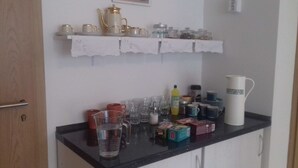 A kitchen counter with various items including a coffee maker, cups, and jars. - Penzion Levandule (Brno)