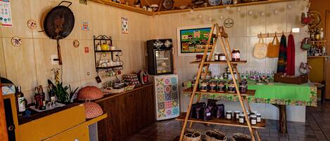 A kitchen with a wooden counter, shelves with jars, a refrigerator, and a ladder shelf.