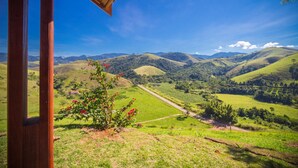 Vista desde una estructura de madera que domina un valle con colinas onduladas y cielo despejado.